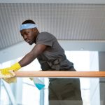 Posh Clean staff cleaning glass railings in a commercial office building in Accra