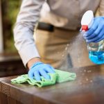Posh Clean technician deep cleaning and disinfecting a surface in Accra