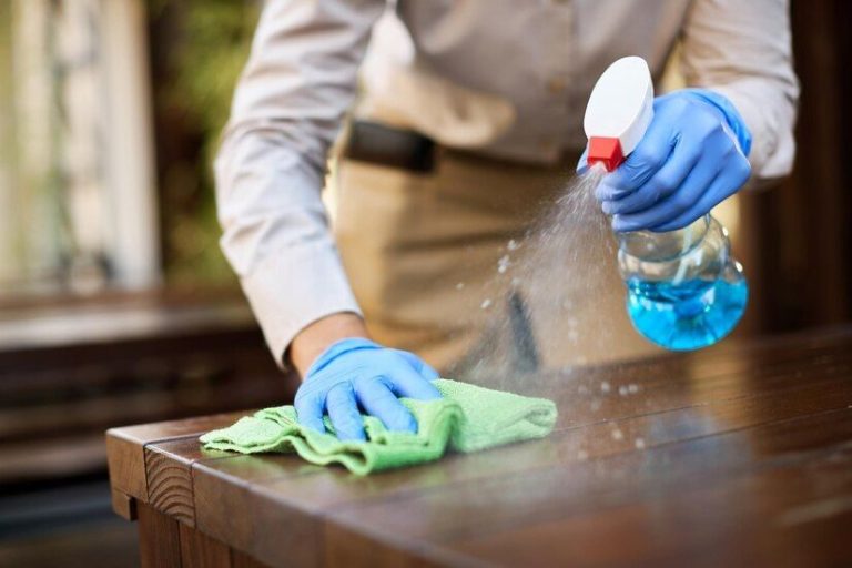 Posh Clean technician deep cleaning and disinfecting a surface in Accra