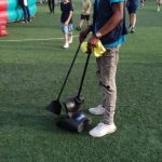 Posh Clean staff member cleaning event grounds on turf in Accra