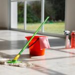 Professional floor cleaning with mop and bucket on a tiled floor in Ghana