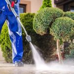 Posh Clean operator pressure washing an exterior paved path in Accra