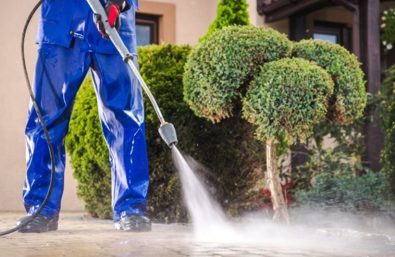 Posh Clean operator pressure washing an exterior paved path in Accra