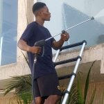 Posh Clean worker cleaning an exterior wall after construction work in Accra
